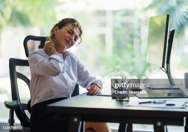 businesswoman having neck ache due to work over load and bad posture - person with a neck pain stock pictures, royalty-free photos & images