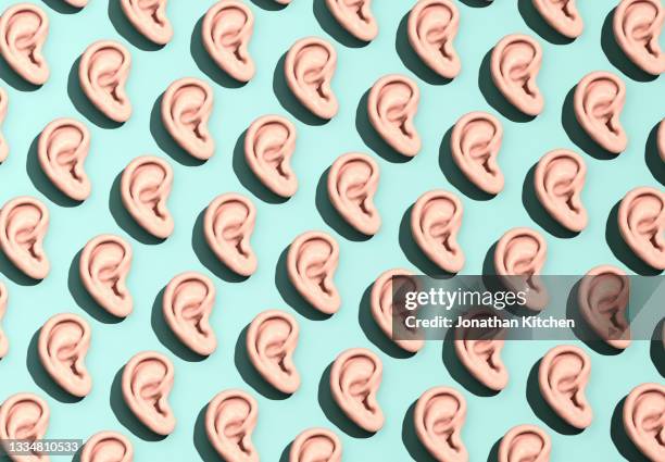 a pattern of ears on a background - luisteren stockfoto's en -beelden