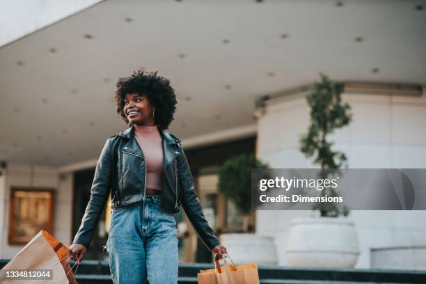 afro female going from shopping - clothing store stockfoto's en -beelden