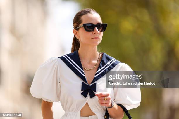 Julia Comil wears a white cropped blouse sailor with bow and puffed sleeves by MiuMiu, cat eye black sunglasses, a vintage gold necklace, on August...