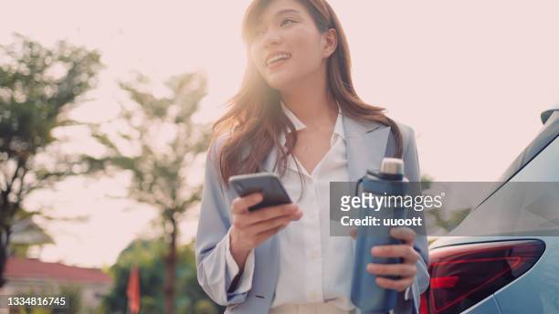 asian young woman using mobile phone - asian woman smiling sunrise stock pictures, royalty-free photos & images
