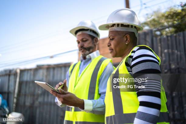 ingegnere e appaltatore che fanno una riunione informale in cantiere - foundations gender equality discussion foto e immagini stock