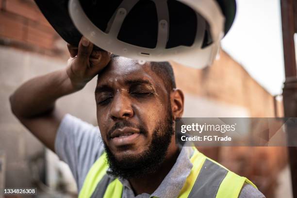 exhausted construction worker at construction site - heat stress stock pictures, royalty-free photos & images