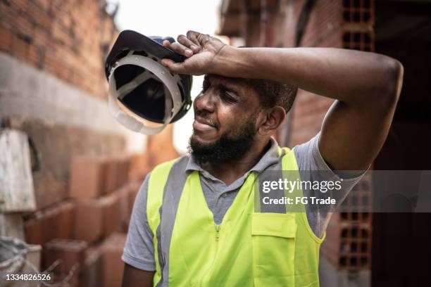 erschöpfter bauarbeiter auf der baustelle - tired worker stock-fotos und bilder