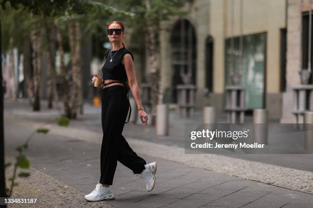 Jana Heinisch wearing Buffalo white sneaker, Lelunes black top and Guess black bag on August 12, 2021 in Cologne, Germany.