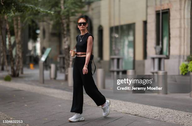 Jana Heinisch wearing Buffalo white sneaker, Lelunes black top and Guess black bag on August 12, 2021 in Cologne, Germany.