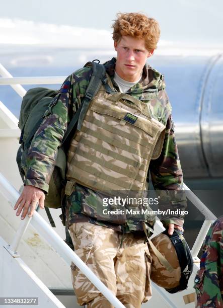 Prince Harry, carrying his rucksack, helmet and wearing a flak jacket, disembarks an RAF Lockheed TriStar transport aircraft as he returns to RAF...