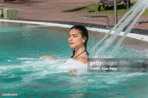 close up of a woman in hydrotherapy waterfall jet in swimming pool - algar waterfall spain stock pictures, royalty-free photos & images