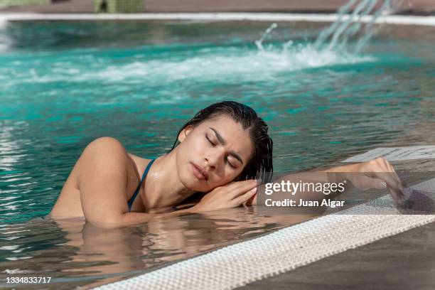 close up view of latina woman relaxing at the edge of the pool - algar waterfall spain stock pictures, royalty-free photos & images