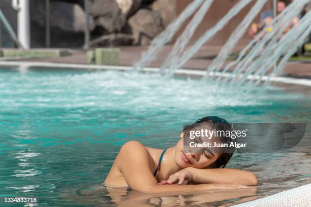 woman relaxing at the edge of the pool - algar waterfall spain stock pictures, royalty-free photos & images