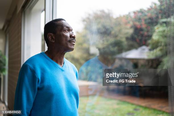 hombre mayor contemplando en casa - sad old man fotografías e imágenes de stock
