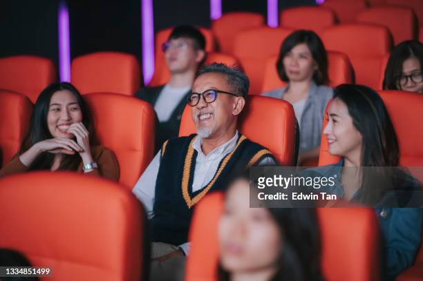 asian chinese active senior man and his  daughter laughing enjoy watching movie in cinema movie - asian cinema stock pictures, royalty-free photos & images