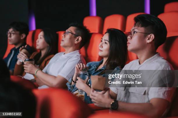 asiatische chinesische gruppe von menschen genießen es, filme im kino am wochenende zu sehen - asian watching movie stock-fotos und bilder