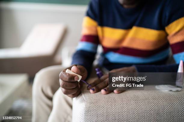 man painting fingernails at home - black gay muscle men stock pictures, royalty-free photos & images