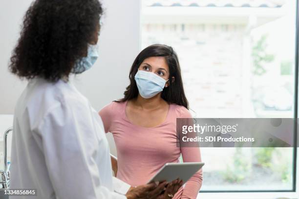 woman with protective mask listens to news given by doctor - facemask 個照片及圖片檔