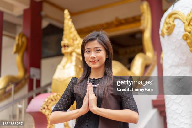 portrait of a young beautiful burmese girl standing in front of a burmese temple. - boeddha's verjaardag stockfoto's en -beelden