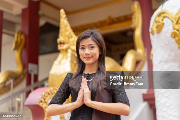 portrait of a young beautiful burmese girl standing in front of a burmese temple. - buddha purnima stock pictures, royalty-free photos & images