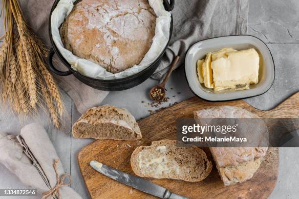 cuisson du pain maison avec tranche fraîche et beurre - pain au levain photos et images de collection