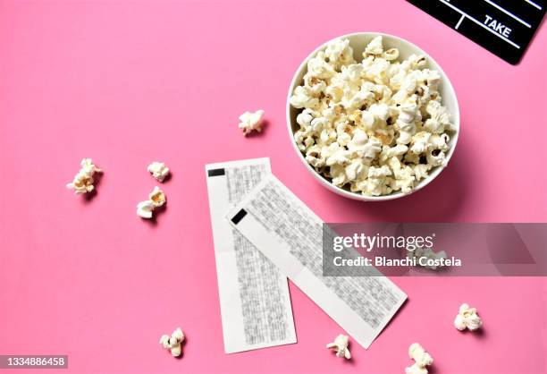 movie clapper, movie tickets and popcorn on pink background - entrada cine fotografías e imágenes de stock