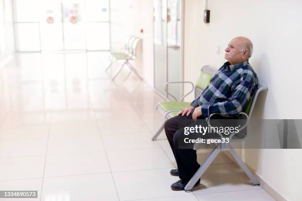 patient sitting in a waiting room - hospital waiting room stockfoto's en -beelden