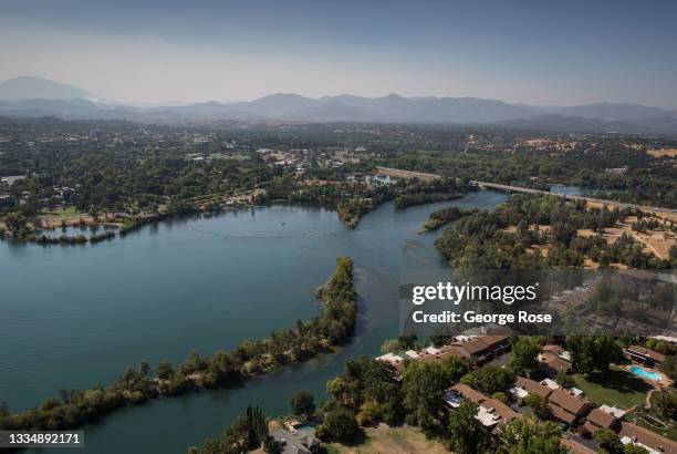 The Sacramento River flows through the downtown area as viewed on a smoky afternoon on August 4 near Redding, California. Redding, a former logging...