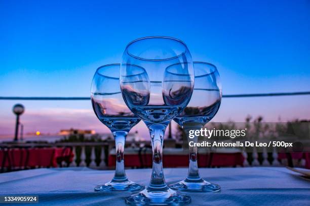 close-up of wineglasses on table against clear sky,san pietro in bevagna,taranto,italy - taranto stock-fotos und bilder