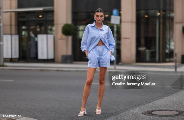 Celine Bethmann wearing blue striped Worst Behavior two piece and white Stradivarius heels on August 16, 2021 in Berlin, Germany.