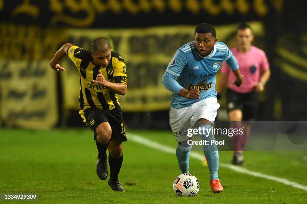 Walter Gargano of Peñarol competes for the ball with Johan Madrid of Sporting Cristal during a quarter final second leg match between Peñarol and...