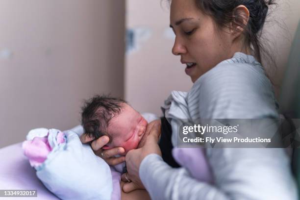 neue mutter stillt ihre tochter im krankenhausbett - family photo in the delivery room stock-fotos und bilder