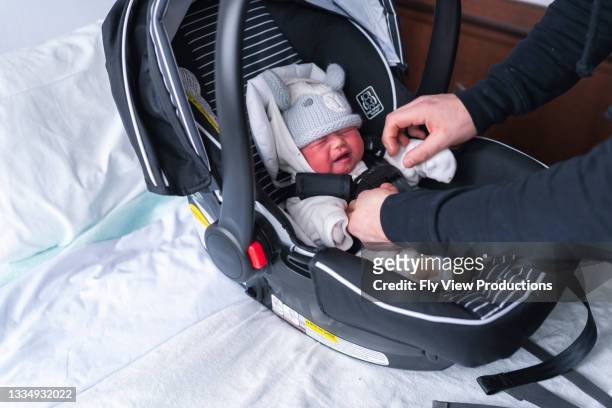 neugeborenes wird in den autoeat gesteckt, um vom krankenhaus nach hause zu gehen - family photo in the delivery room stock-fotos und bilder