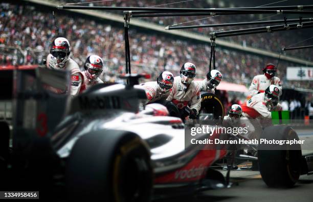 British McLaren Formula One team racing driver Jenson Button driving his MP4-27 racing car arrives at the McLaren pit lane, pit stop box for a wheel...