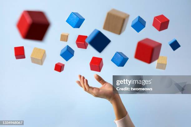 hand trying to grab a cube in mid air still life. - catching hands stock pictures, royalty-free photos & images