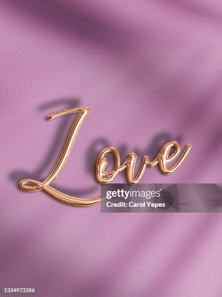 love word in gold foil balloon - ballon de baudruche doré photos et images de collection