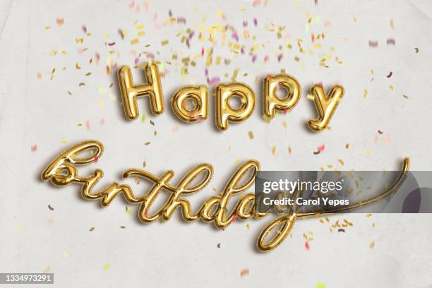 happy birthday in golden balloon with glitter confetti - balloon letters stock pictures, royalty-free photos & images