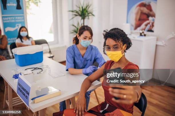 patient taking selfie in the covid-19 vaccination center - vaccination centre stock pictures, royalty-free photos & images