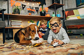 Playful superheroes and their dog spending fun time together during Halloween season
