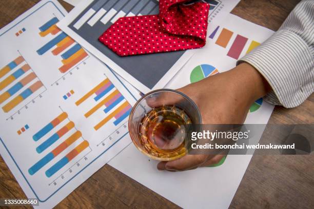drunk man with a glass of brandy on report graph. - passed out drunk stockfoto's en -beelden