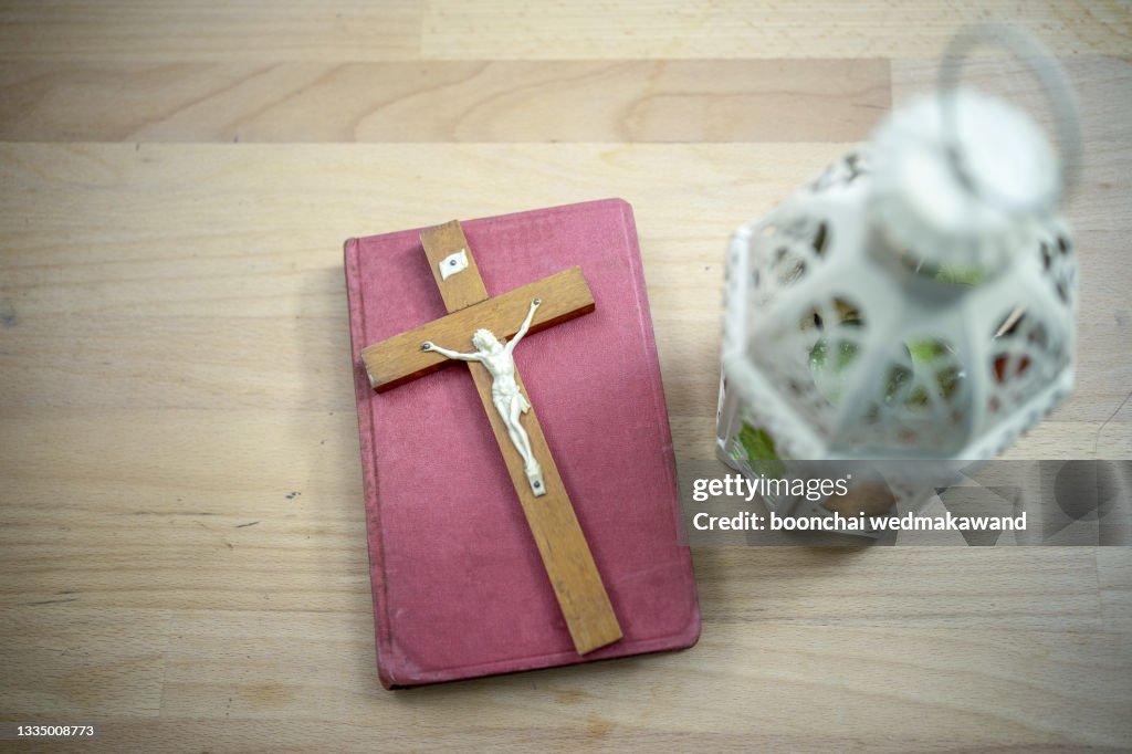 Bible and cross on desk.