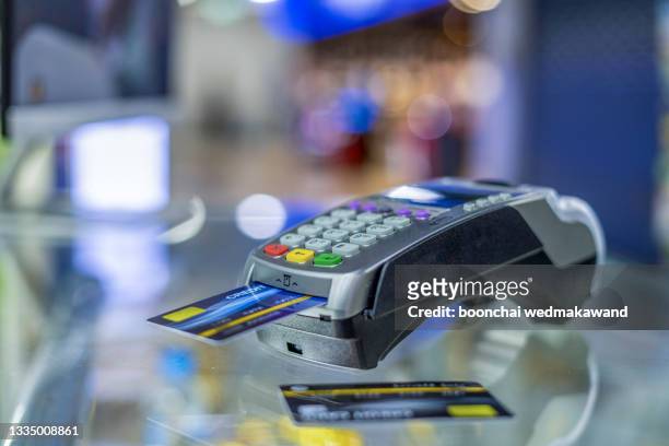 swipe a credit card to buy products online - consumer electronics industry stock pictures, royalty-free photos & images