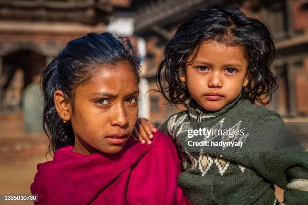 nepali girls holding her little sister, durbar square of bhaktapur - nepali people stock pictures, royalty-free photos & images