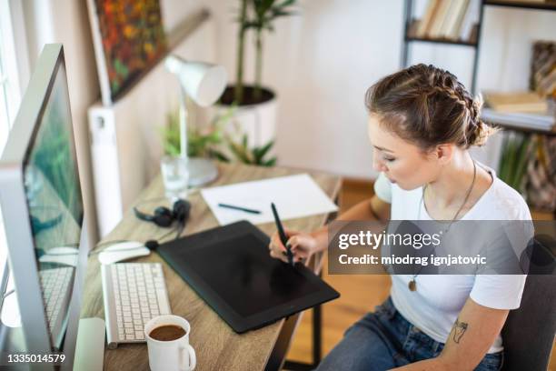 graphic designer drawing on graphics tablet while working from home - graphic designer sketching stock pictures, royalty-free photos & images