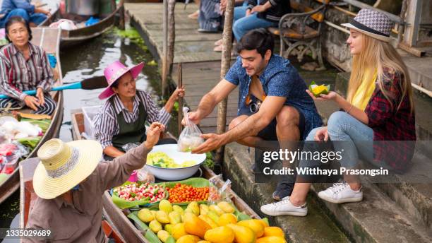 fruit vendors at damnoen saduak floating market, thailand - thaïse gerechten stockfoto's en -beelden