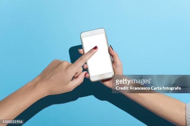 woman hand holding smartphone - contact color background photos et images de collection