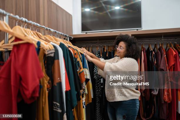 afro-frau kauft kleidung - clothes rack stock-fotos und bilder