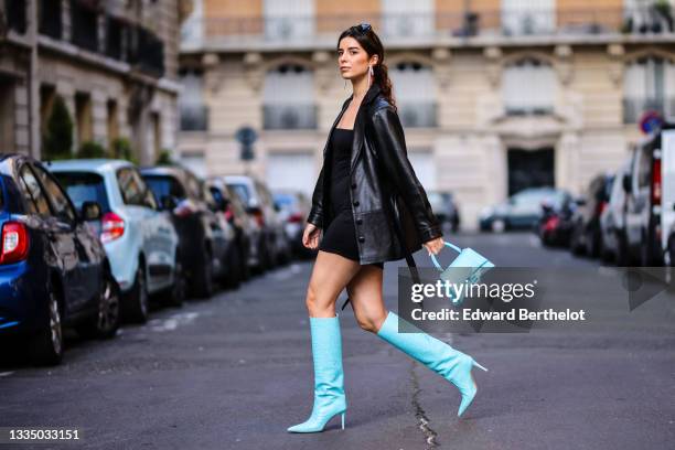 Ketevan Giorgadze @katie.one wears black oversized sunglasses from Prada, large silver chain and rhinestones pendant earrings, a black V-neck little...