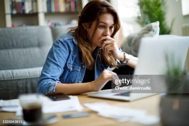 worried young woman working at home - tillerson and mattis testify at senate hearing on authorization of use of force stockfoto's en -beelden