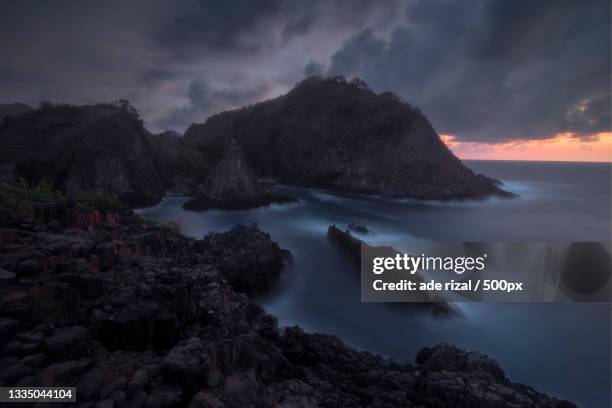 scenic view of sea and mountains against sky during sunset,west nusa tenggara,indonesia - ade rizal stockfoto's en -beelden