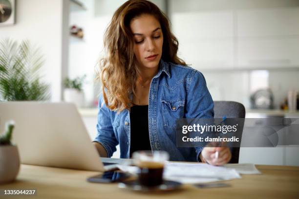 young woman working from home - thinking for investment stock pictures, royalty-free photos & images