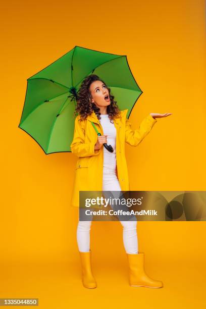 girl with green umbrella - rain coat stock pictures, royalty-free photos & images