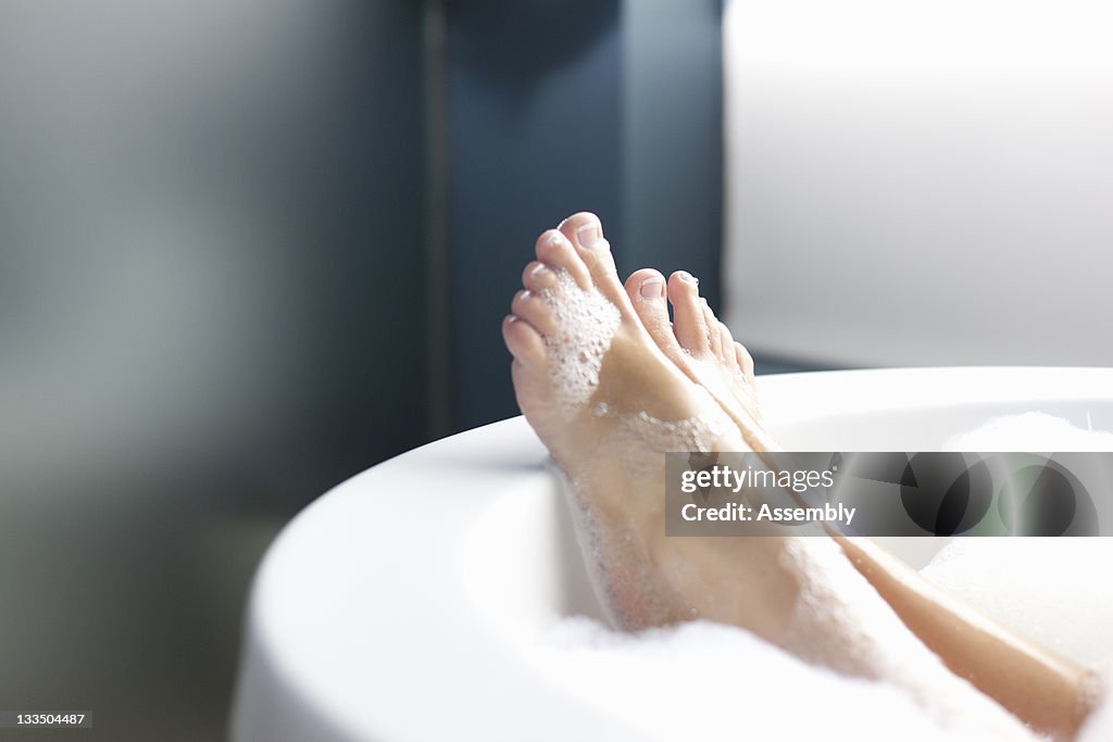 Feet of woman relaxing in bubble bath